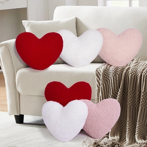 Detail of red, white and pink heart-shaped pillows in textured faux fur fabric