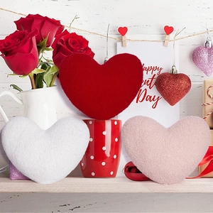 Detailed texture of heart-shaped sherpa cushions in red, white and pink for home decor