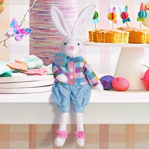 Detail of Easter plush bunny doll holding a Happy Easter sign in a festive setting