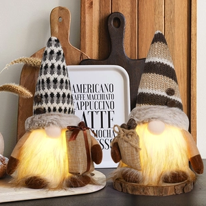 Close-up of lighted coffee gnomes with knitted hats and warm LED glow on wooden base