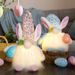 Detail of light-up Easter gnomes with sequin hats and warm LED glow on wooden base