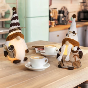 Close-up of lighted coffee gnome plush ornaments with coffee bean details and warm LED glow