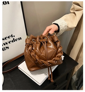 Detailed view of caramel brown quilted leather bucket bag with braided rope handle
