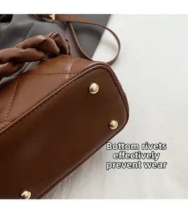 Detail of dark brown leather bucket bag base with protective gold-tone metal rivets