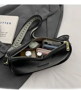 Gros plan de l'intérieur du sac demi-lune noir montrant sa grande capacité de rangement