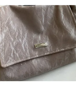 Close-up of modern tote bag featuring marble textured fabric and a metal logo plate