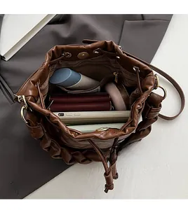 Top view of spacious interior with drawstring closure on brown PU leather bucket bag