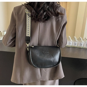 Détail du sac à bandoulière en cuir grainé noir avec sangle tissée géométrique