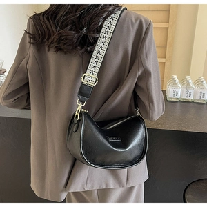 Détail du sac demi-lune noir avec bandoulière réglable aux motifs géométriques