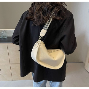 Détail du sac beige en cuir PU texturé avec bandoulière large tissée géométrique