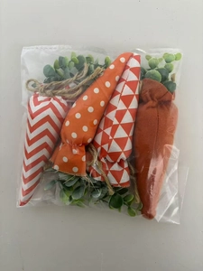 Detailed close-up of four fabric Easter carrot ornaments with diverse patterns and twine loops