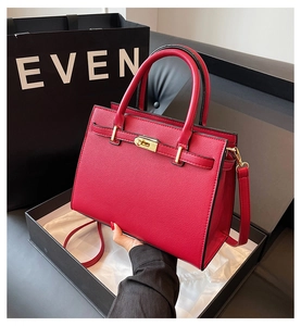 Detail of red lychee textured bridal handbag with gold-tone hardware and lock closure