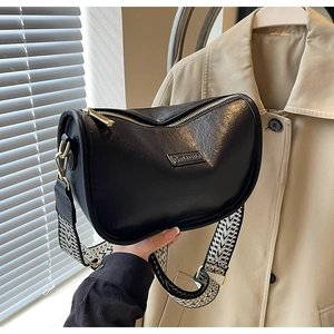 Détail du sac croissant en cuir noir avec bandoulière géométrique et dorures