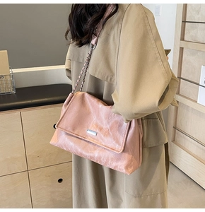 Detail of pink tote bag featuring marble texture and metallic chain shoulder strap