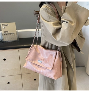 Macro view of pink marble-textured leather bag with silver chain and metal clasp