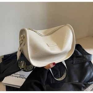 Détail d'un sac bandoulière blanc crème montrant le grain litchi et la large sangle