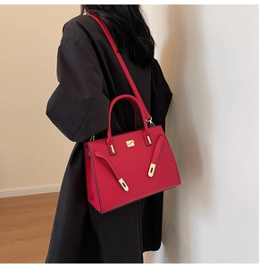 Detail of red bridal handbag with adjustable shoulder strap and gold-tone metal hardware