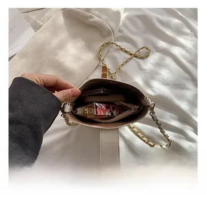 Interior view showing the capacity of this cream leather crossbody bag with chain strap