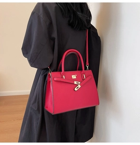 Rear view of model wearing a red leather wedding handbag with gold hardware