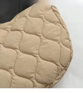 Close-up of beige quilted nylon fabric with wavy stitching on a versatile tote bag