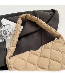 Close-up of beige quilted nylon shoulder bag with wavy stitching and soft texture