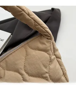 Detail shot of wavy quilted light khaki nylon handbag showing soft padded stitching texture