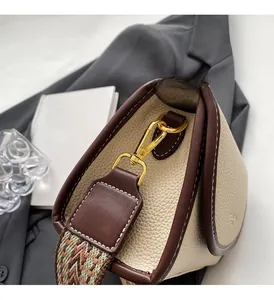 Détails du sac en cuir grainé beige avec ferrures dorées et bandoulière tissée rétro