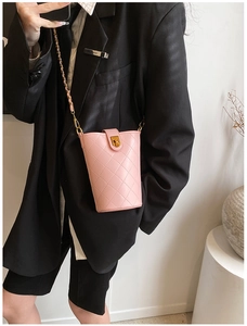 Pink quilted bucket bag with gold chain strap worn over a black blazer for detail
