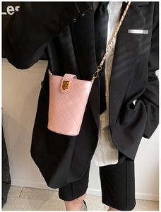 Detail of pink quilted crossbody bag with gold chain strap and vintage twist lock