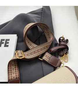Détail de la bandoulière tressée ethnique et du bracelet en cuir marron avec boucle dorée