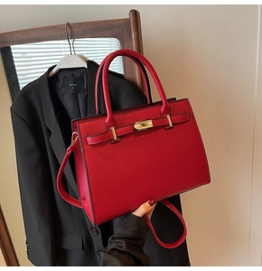 Detail view of red lychee texture wedding handbag with gold lock and detachable strap