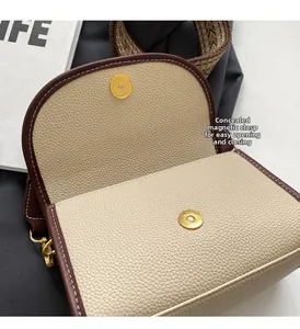 Détail du sac bandoulière bicolore avec fermoir magnétique caché et sangle tissée large