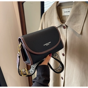 Détail du sac bandoulière en cuir noir avec sangle jacquard géométrique vintage