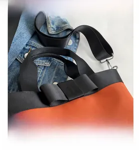Detail of orange nylon bucket bag with large black bow and silver metal clasp hook