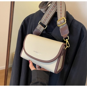Détail du sac bandoulière en cuir grainé crème avec sangle jacquard et dorures