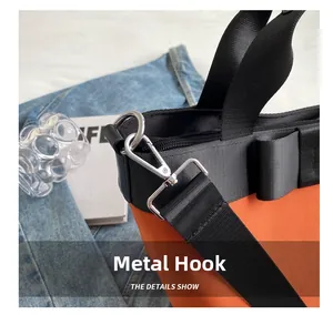 Detail of silver metal hooks and adjustable strap on an orange nylon bucket bag