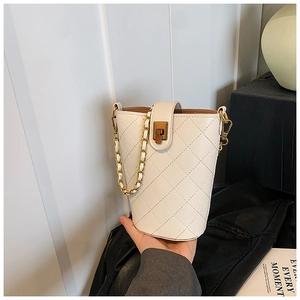 Close-up of white quilted bucket bag with vintage gold buckle and chain strap detail