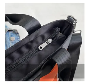 Detail of smooth metal zipper and black nylon fabric texture on a large bucket bag