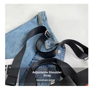 Detail of adjustable black nylon strap with silver metal buckle on blue denim tote bag