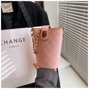 Detail of pink quilted leather bucket bag with gold chain and turn-lock closure