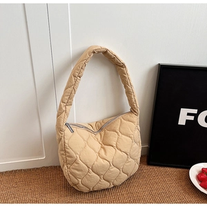 Detail of light khaki quilted nylon tote bag with rhombus patterns and zipper closure