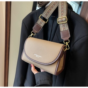 Détail du sac en cuir kaki avec surpiqûres blanches et bandoulière tissée à motifs