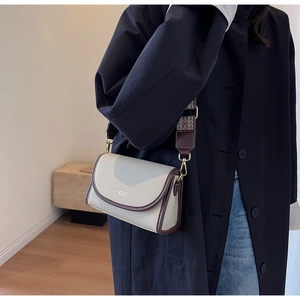 Détail du sac bandoulière rétro bicolore en cuir texturé avec sangle tissée