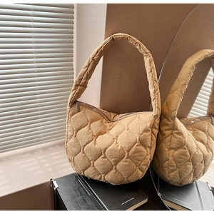 Detailed view of khaki quilted crescent bag with soft nylon texture and metal zipper