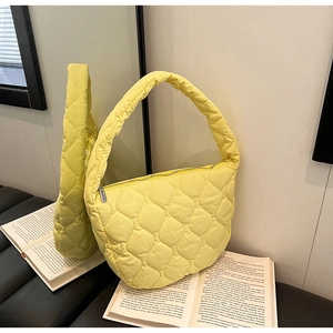 Detailed view of yellow quilted nylon tote with gourd stitching and silver zipper closure