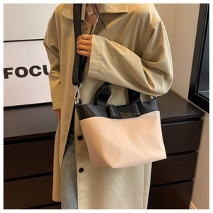 Nylon bucket bag detail showing contrast color design and elegant black bow decoration