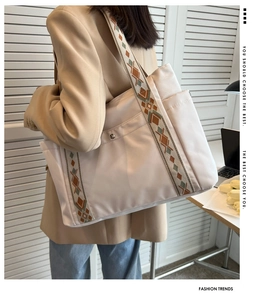 Detail of cream nylon tote bag featuring wide geometric jacquard shoulder strap for work