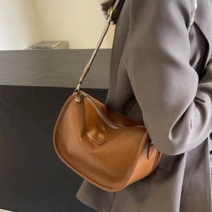Sac hobo marron en cuir avec bandoulière tressée et fermeture éclair dorée