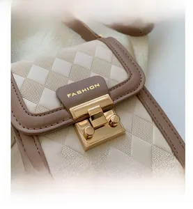 Detail der gesteppten Handytasche in Beige und Braun mit goldener Schließe und Fashion Logo