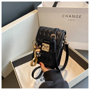 Detailansicht der schwarzen gesteppten Handytasche mit goldenen Details und Plüschtier
